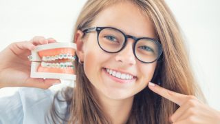 歯の矯正の仕組みを説明する女性